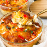 Mini Cheesy Red Pepper Hashbrown Breakfast Bakes in a bowl with a fork.