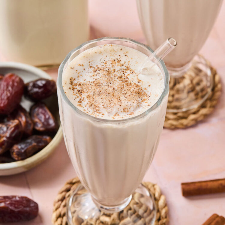 Cinnamon Vanilla Date Milkshake in a glass with a straw.