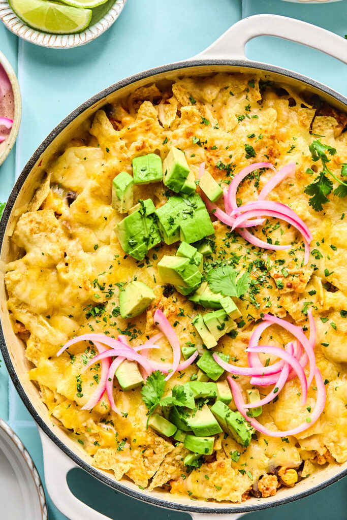 Cheesy Turkey Taco Skillet topped with avocado and red onion in a skillet.