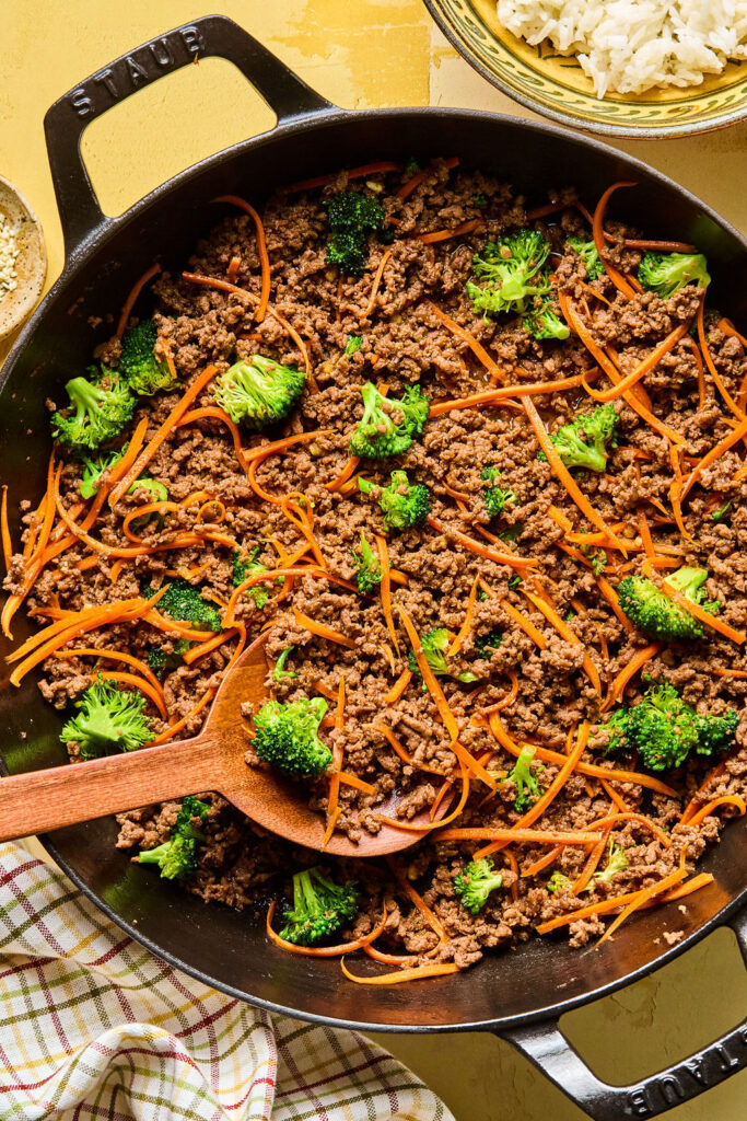 Honey Garlic Ground Beef Bowls in a skillet with a wooden spoon.