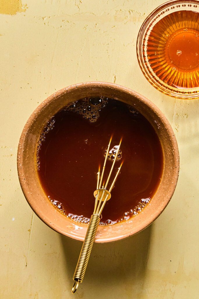 Honey Garlic Ground Beef Bowls sauce in a small bowl with a whisk.