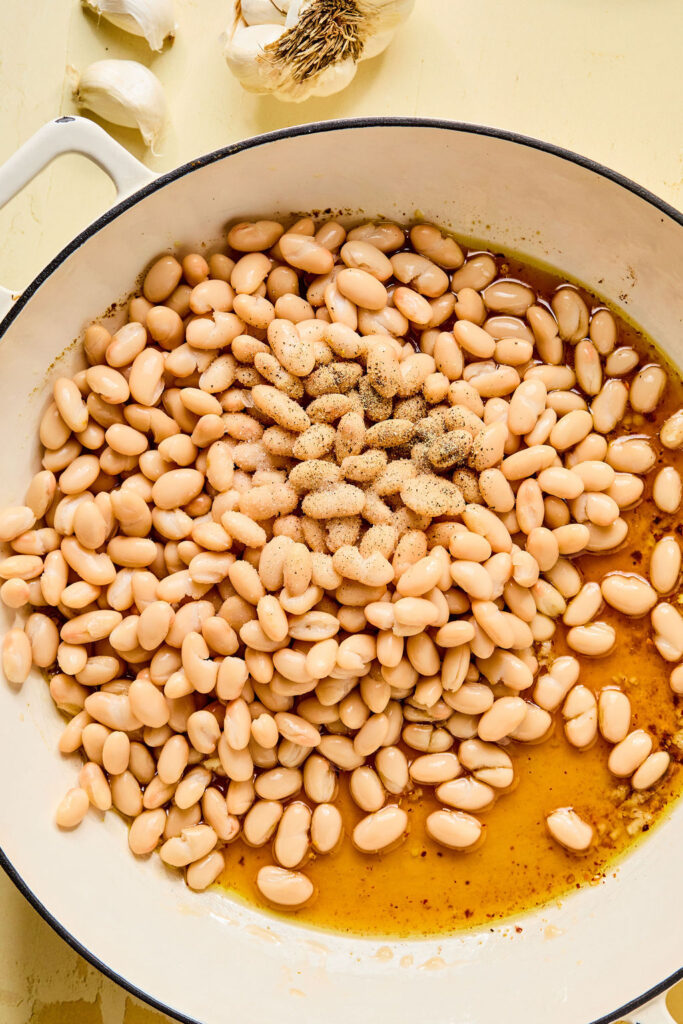 Beans and broth added to the skillet.