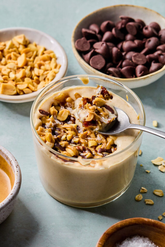 Snickers Blended Overnight Oats in a jar with a spoon.