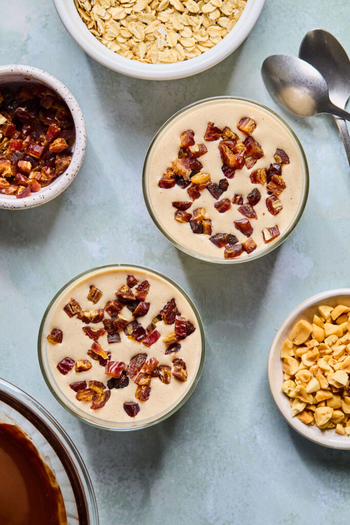 Chopped dates sprinkled on top of the jars of Snickers Blended Overnight Oats.
