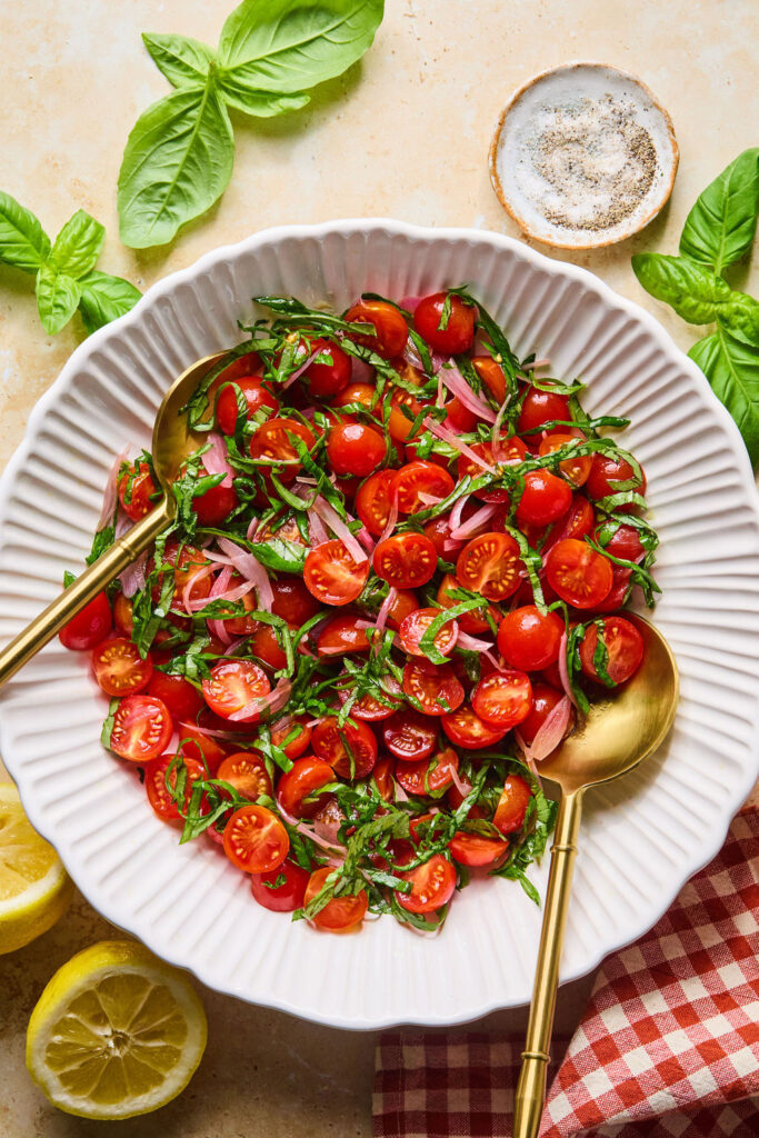 Vegetables for Crispy Goat Cheese & Tomato Salad recipe in a bowl with spoons.