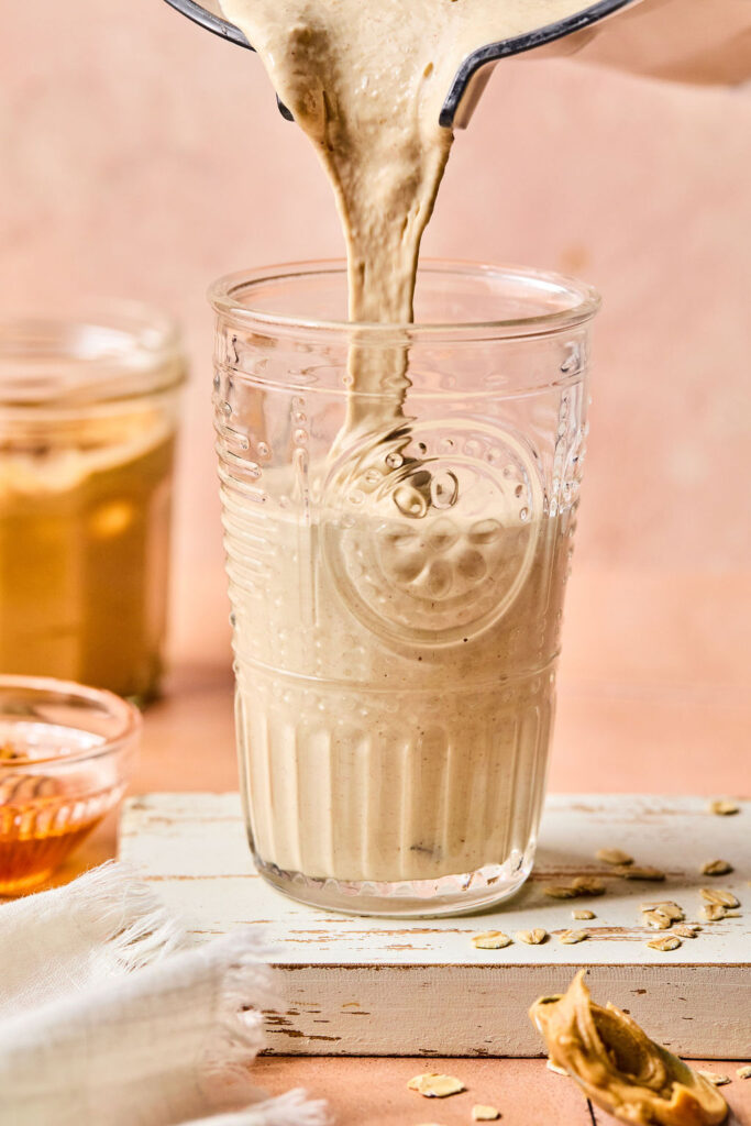 Peanut Butter Smoothie being poured in a glass.