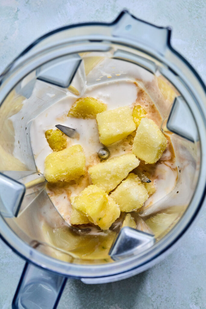 Ingredients for Ninja Creami Pineapple Sorbet in a food processor bowl before being blended up.