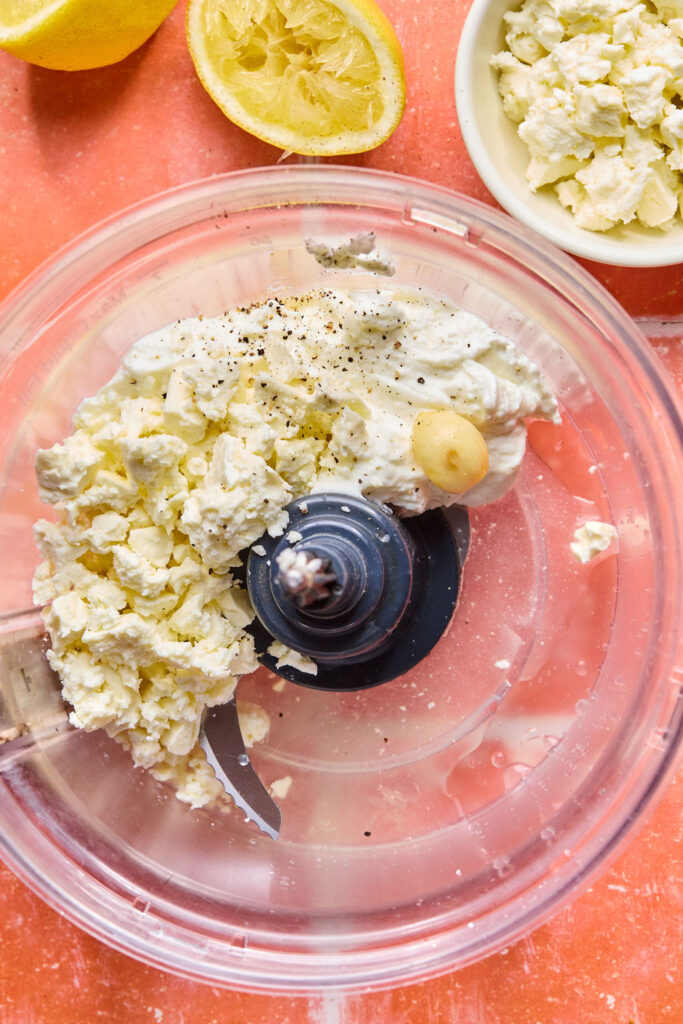 Ingredients for whipped feta sauce in a food processor bowl.