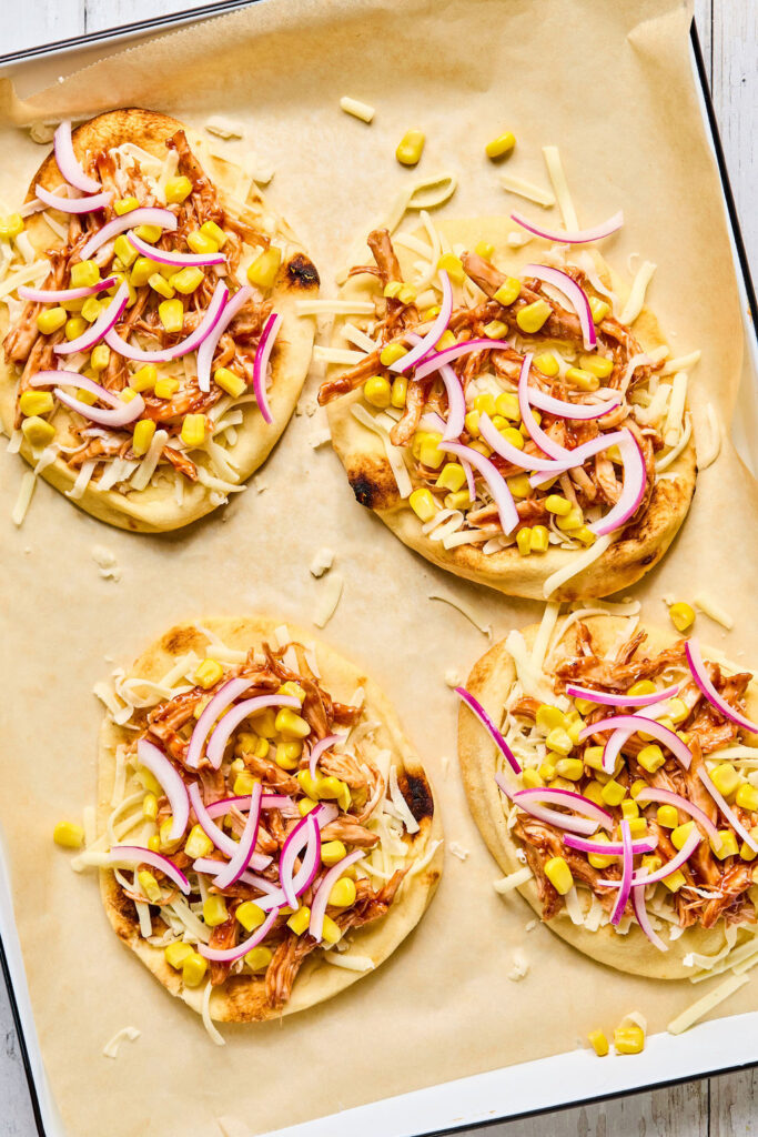 Sheet Pan BBQ Chicken Flatbread on a sheet plan before being baked.