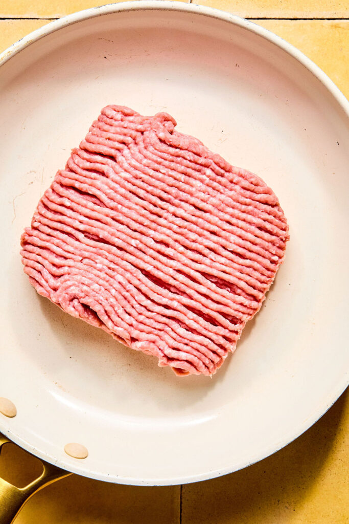 Raw ground turkey in a skillet.