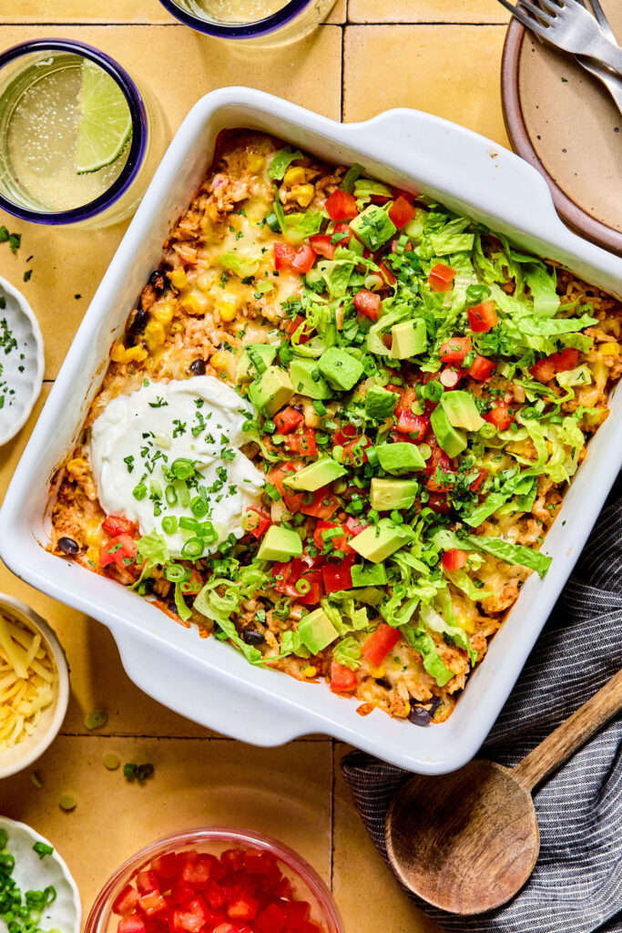 Cheesy Turkey Taco Rice Bake topped with avocado, pico de gallo, and sour cream.