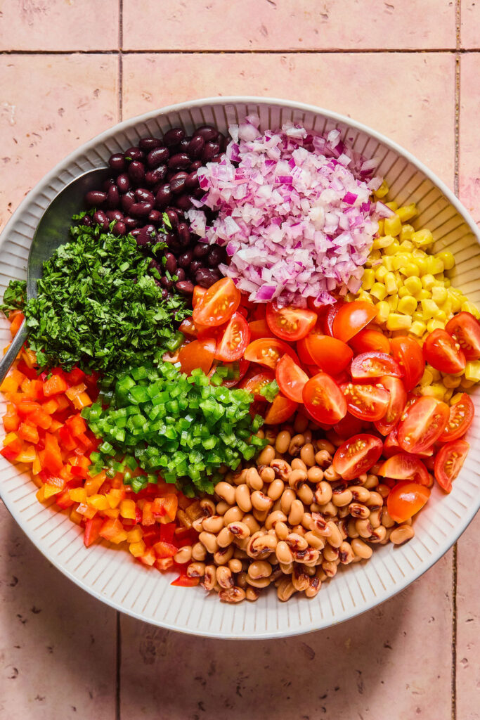 Ingredients for Rainbow Cowboy Caviar in a bowl before being mixed together.