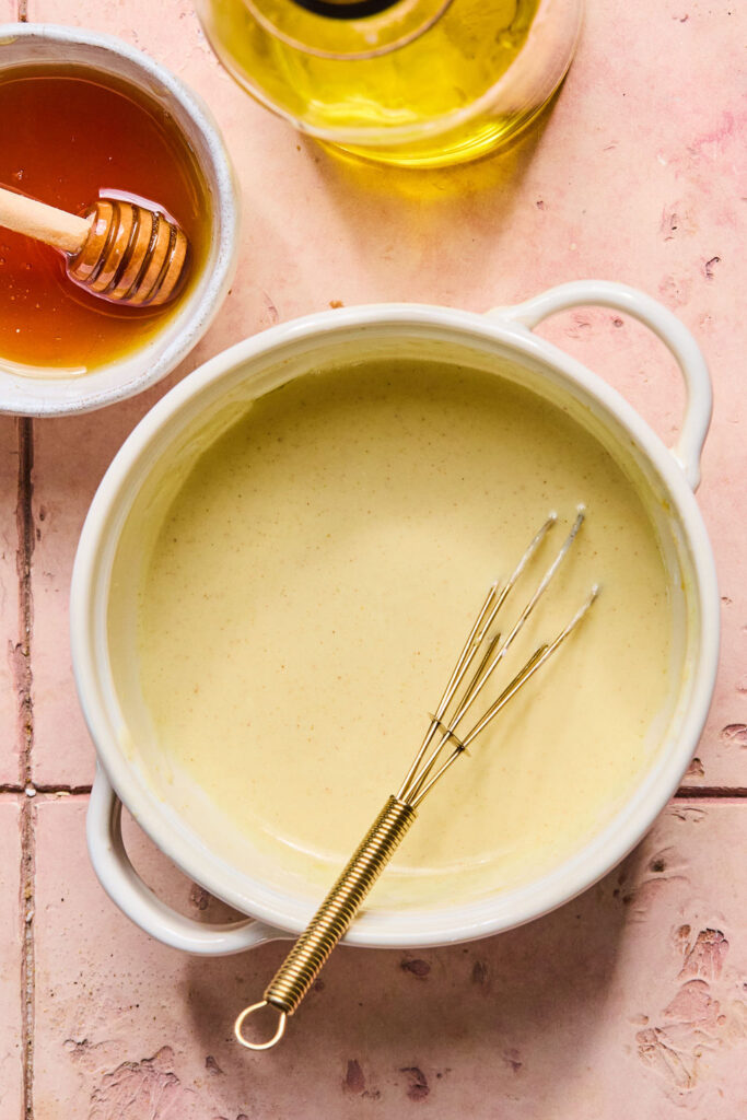Dressing in a small bowl with a whisk.