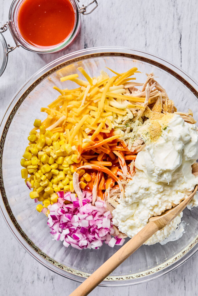 Ingredients for Buffalo Chicken Enchilada Bake in a bowl before being mixed together.