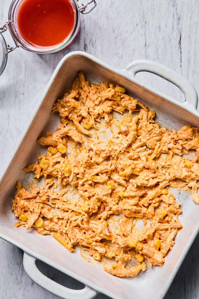 Chicken mixture in a square baking dish.