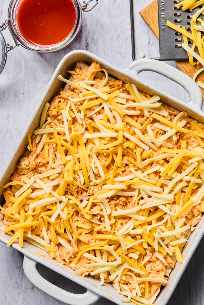 Shredded cheese added on top of the tortillas and chicken mixture.