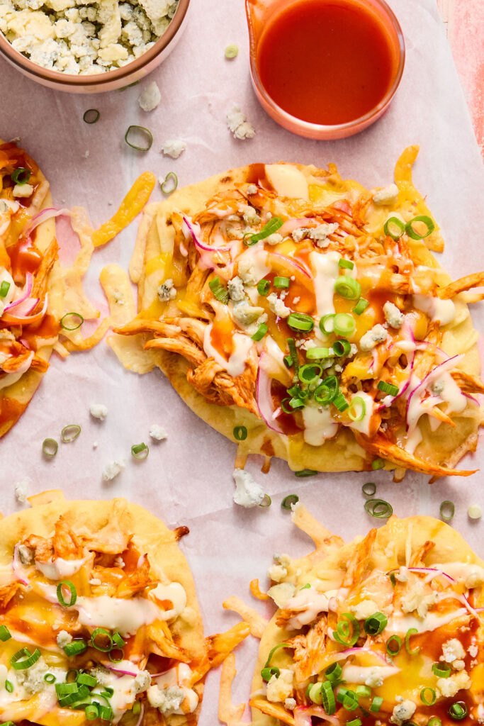 Zoomed in view of  Buffalo Chicken Flatbread on parchment paper.