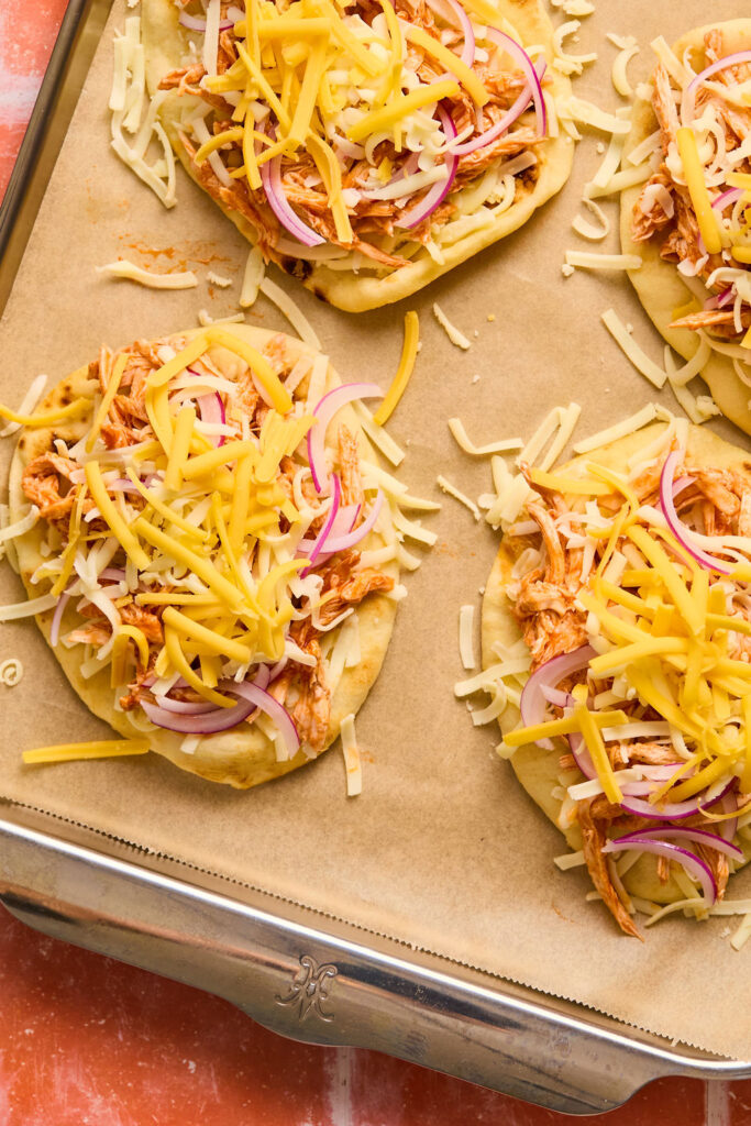  Buffalo Chicken Flatbread on a baking sheet with parchment paper before being baked.