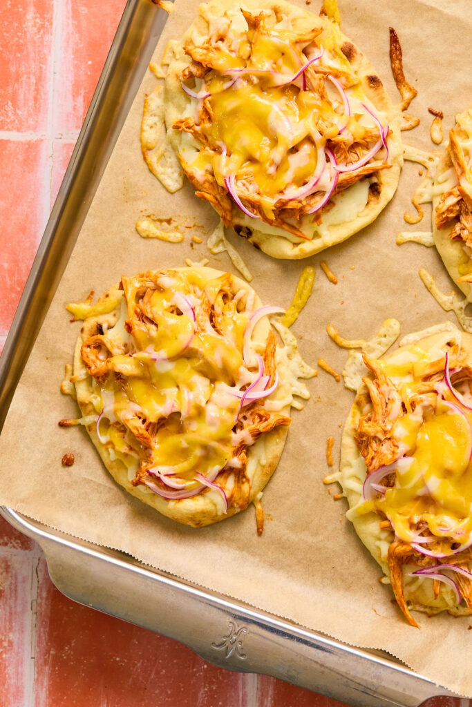  Buffalo Chicken Flatbread on a baking sheet with parchment paper after being baked.