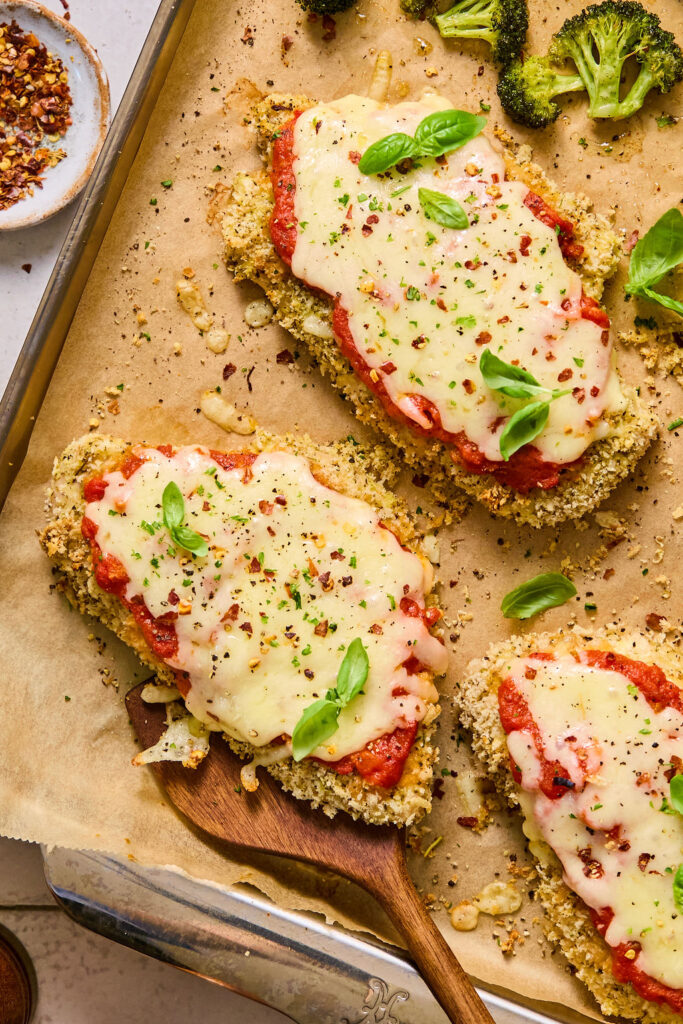 Sheet Pan Chicken Parmesan on a sheet pan with parchment paper.