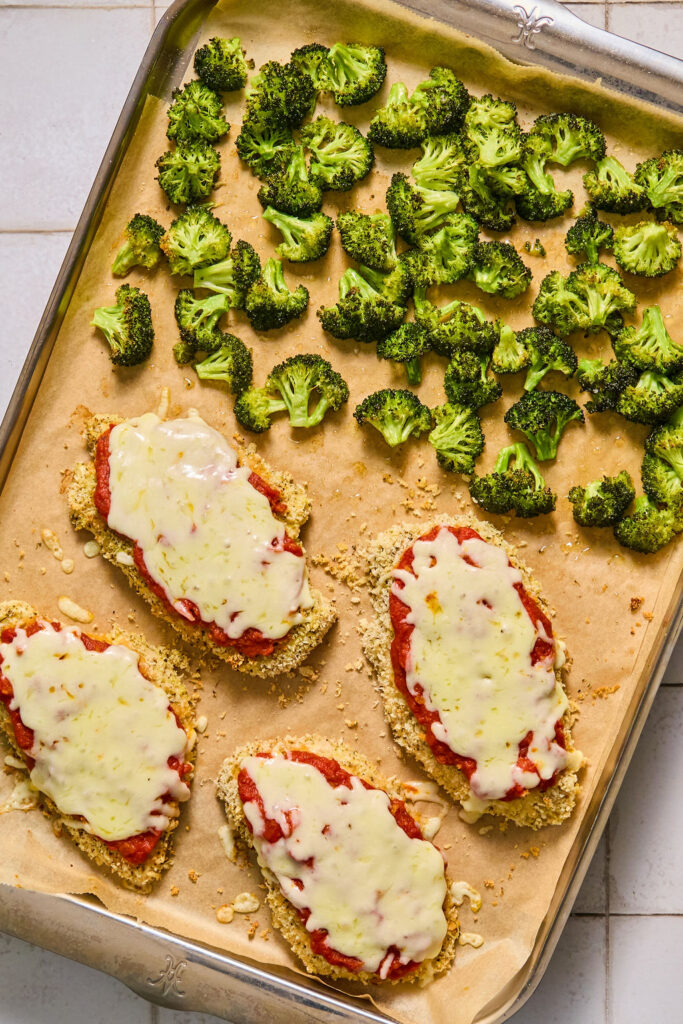 Sheet Pan Chicken Parmesan and Broccoli on a sheet pan after being baked.
