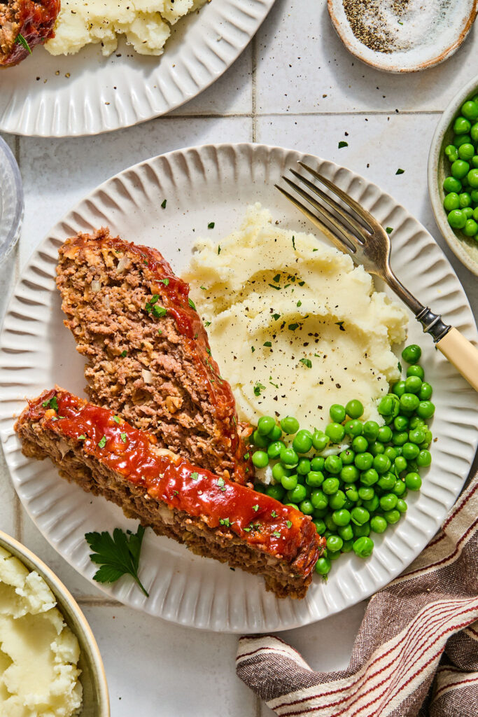 Meatloaf with Oats with mashed potatoes and peas on a plate.
