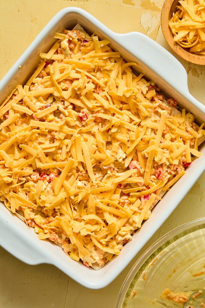 Shredded cheese added on top of the chicken mixture.