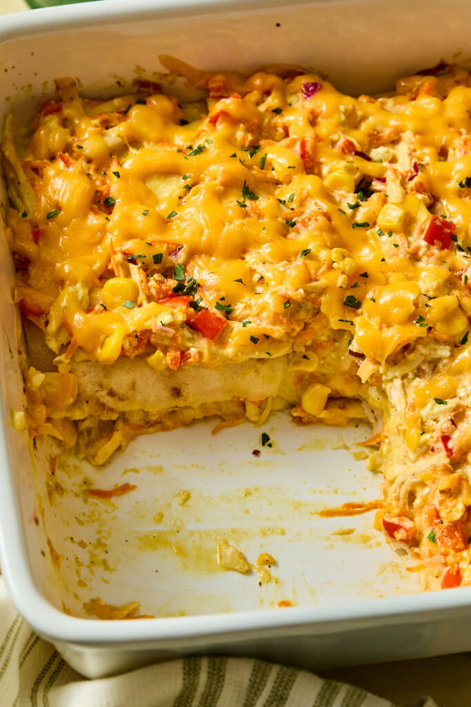 Zoomed in view of Honey Mustard Chicken Enchilada Casserole in a baking dish.